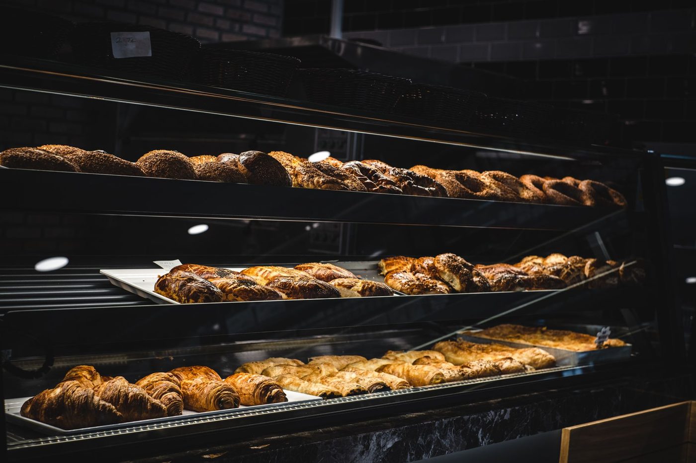 Présentoir de viennoiseries et baguettes dans la vitrine de la boulangerie